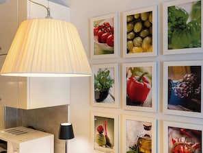 A kitchen area with a white microwave, a black lamp, and a large wall-mounted lamp.
