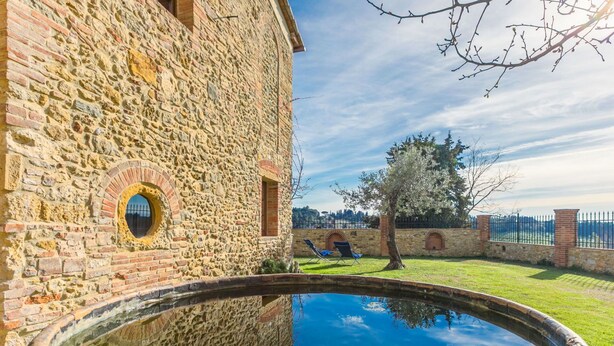 A stone building with a circular pool and a tree in the background. - Beautiful private villa for 3 people with A/C, WIFI, patio and panoramic view (Montescudaio)