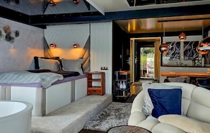 A modern interior with a bed, seating area, and a view of the outdoors. - Beautiful ship in Sagard with sauna (Sagard)