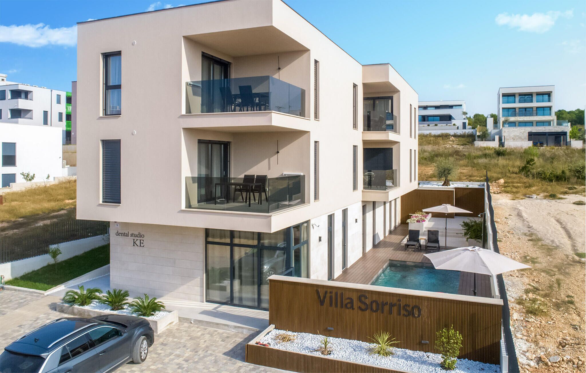 A modern villa with a pool, balconies, and a sign reading "Villa Sorriso".