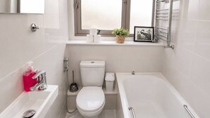 Un baño moderno con inodoro, bidé y bañera.