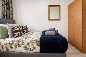 A bedroom with a bed, pillows, a mirror, and a wardrobe. - Little Venice apt near Paddington + garden & Wi-Fi (London)