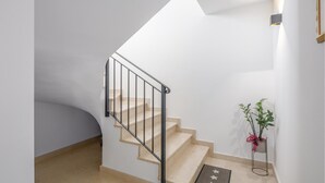 A staircase with a black handrail, beige steps, and a small potted plant with green leaves and a pink ribbon. - Awesome apartment in Porec with WiFi (Porec)