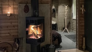 A cozy room with a wood-burning stove, a coat rack, and a dog. - Stunning home in Eggedal with WiFi (Eggedal)