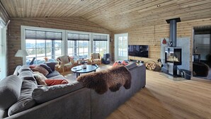 A cozy living room with a large sofa, a fireplace, and a television. - Stunning home in Eggedal with WiFi (Eggedal)