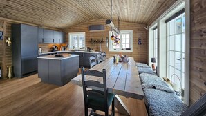 A modern kitchen with a central island, wooden flooring, and large windows. - Stunning home in Eggedal with WiFi (Eggedal)