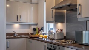 Een moderne keuken met roestvrijstalen apparatuur, een inbouwoven en een groot raam boven de gootsteen.