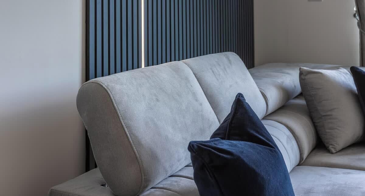 A modern living room with a sofa and cushions.