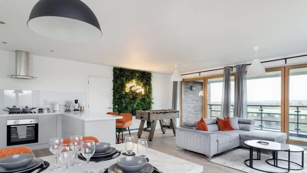 A modern apartment with a kitchen, dining area, and living room.