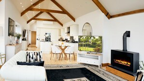 Ein modernes Wohnzimmer mit Kamin, Essbereich und Küche.