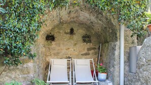 A stone archway with two white lounge chairs and a potted plant. - Awesome apartment in Verni (LU) with WiFi (Verni)