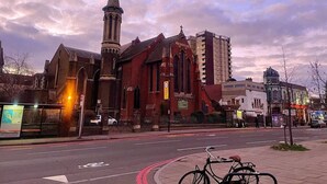 A historic church with a tall steeple and a modern building adjacent to it. - Hackney Suites - Triple En-suite Room (G1) (Greater London)