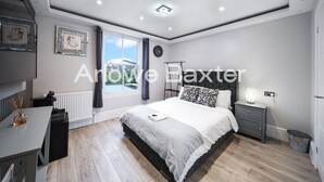 Une chambre à coucher moderne avec un lit, une table de chevet et une vue sur l’extérieur.