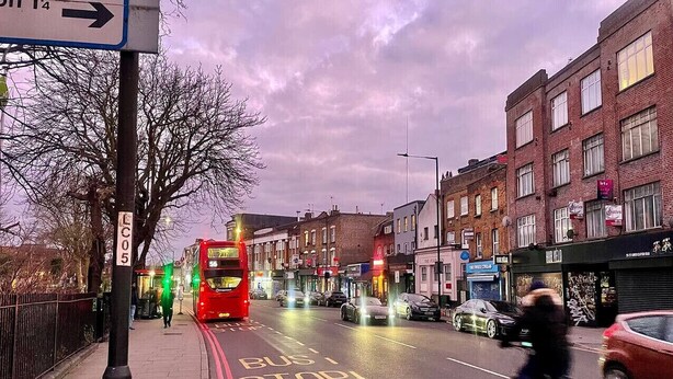 A street scene with a bus stop, buildings, and a cyclist. - Hackney Suites - Double En-suite Room (B1) (Greater London)