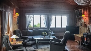 Un salon chaleureux avec un canapé, des fauteuils, une table basse et une cheminée.