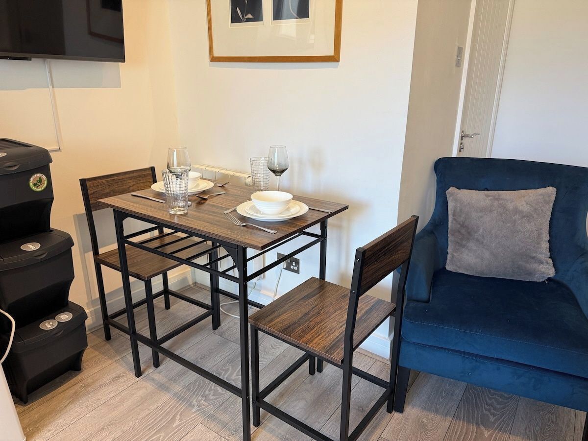 A dining area with a table, chairs, and a blue sofa.