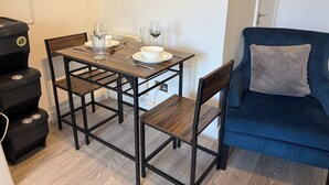 Et spiseområde med et bord, stole og en blå sofa.