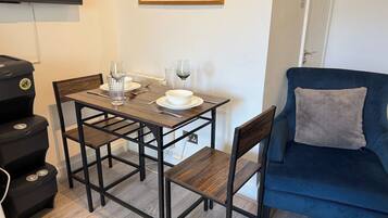 A dining area with a table, chairs, and a blue sofa.