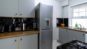 A modern kitchen with stainless steel appliances, a gas stove, and a window with a view. - Open Mind Property - Southsea with Free Parking (Portsmouth)