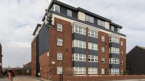 A multi-story residential building with a brick facade and large windows. - Open Mind Property - Southsea with Free Parking (Portsmouth)