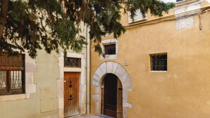 A courtyard with a stone staircase leading to an arched entrance, a wooden door, and a small window. - Bravissimo Girona 1593, Medieval charm in the heart of Girona Jewish quarter (Girona)