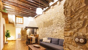 A rustic interior with a stone wall, wooden furniture, and a tiled floor. - Bravissimo Girona 1593, Medieval charm in the heart of Girona Jewish quarter (Girona)