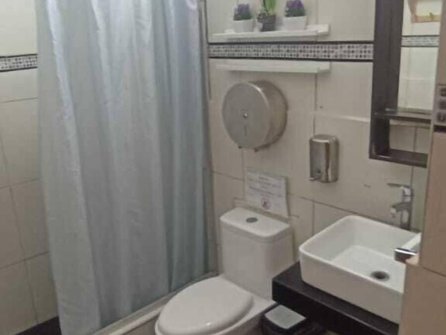 A small bathroom with a toilet, sink, and shower curtain.