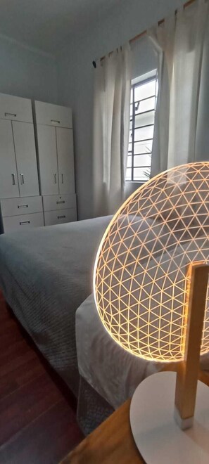 A bedroom with a bed, a wardrobe, and a table lamp. - Casita Libertad Barranco (Lima)