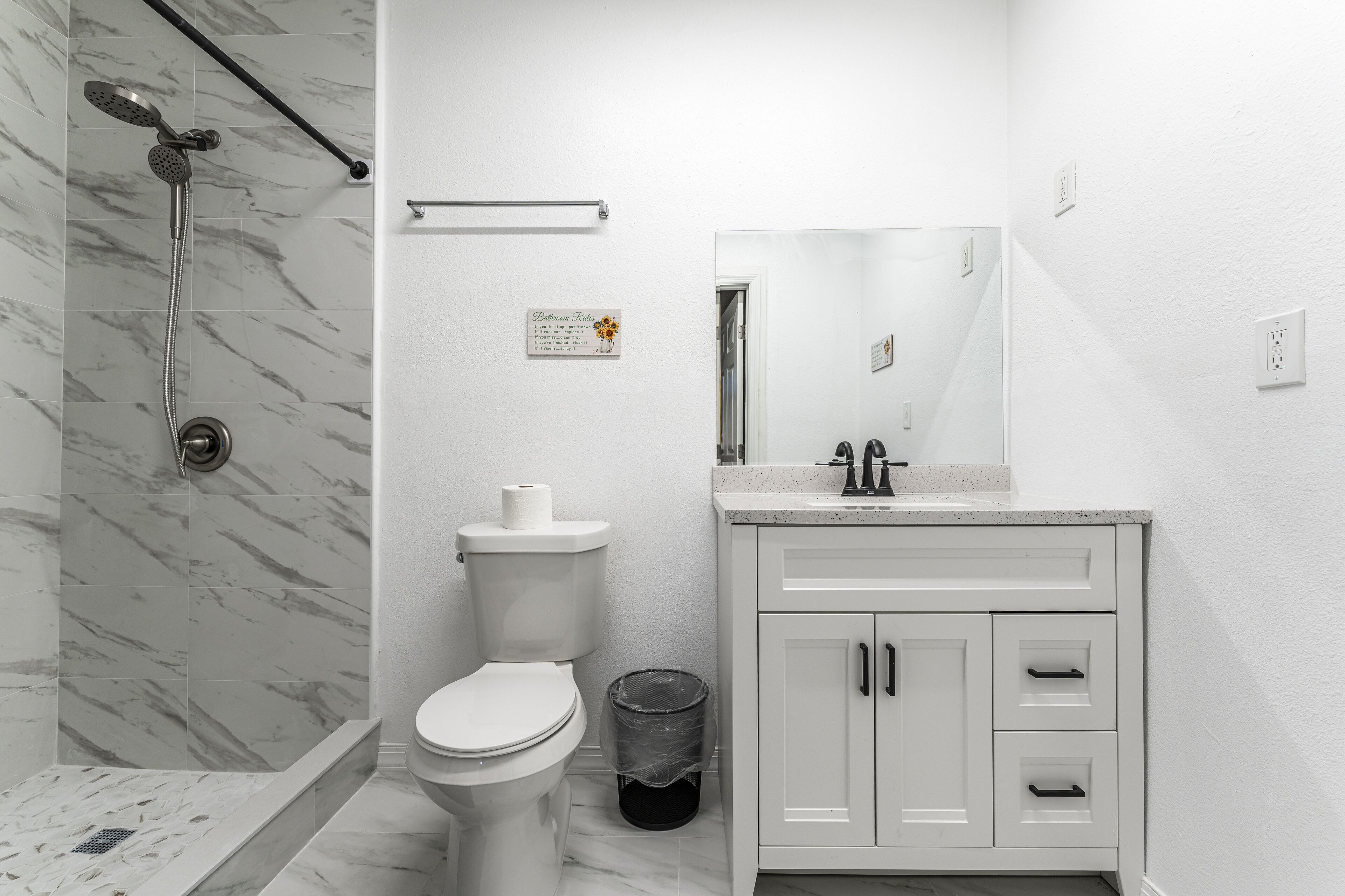 Un baño moderno con ducha, inodoro y tocador.
