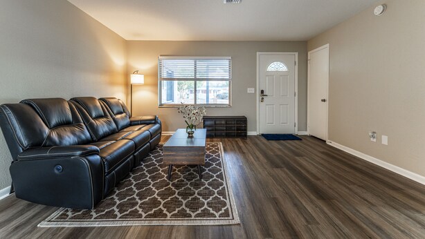 A living room with a leather sofa, a coffee table, and a patterned rug.