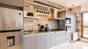 A modern kitchen with a stainless steel refrigerator, a built-in oven, and a microwave. - Gente del Sur - Fique (Ushuaia)