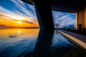A sunset view from under a bridge with calm water reflecting the sky. - WealthyStays: Nicosia Heights (Nicosia)