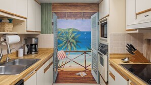 Une cuisine avec vue sur la plage, un hamac et un plafond en bois.