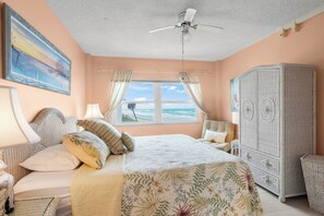 A bedroom with a bed, a ceiling fan, a window with curtains, a dresser, and a painting on the wall. - Oceanfront Oasis - 2BR/2BA direct oceanfront! (Satellite Beach)