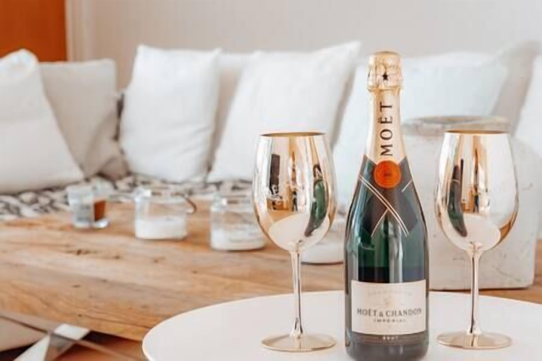 A bottle of Moët & Chandon champagne on a table with two glasses.