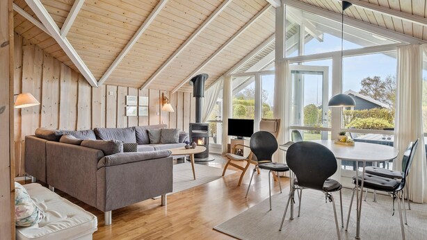 A cozy living room with a sofa, chairs, a TV, and a wood-burning stove. - Beautiful home in Sydals with kitchen (Sydals)