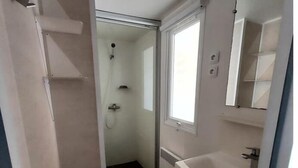 A compact bathroom with a shower, toilet, and sink. - Mobil Home - N025 (Bootzheim)