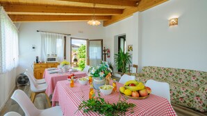 A dining area with a red and white checkered tablecloth, white chairs, and a fruit bowl on the table. - Awesome home in Montefalcone Appennino (Montefalcone Appennino)