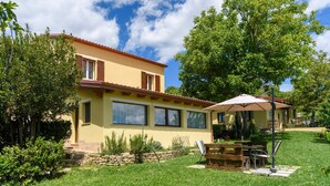 A yellow house with a red roof, a stone wall, and a patio with a table and chairs. - Awesome home in Montefalcone Appennino (Montefalcone Appennino)
