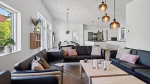 A modern living room with a sofa, coffee table, and pendant lights.