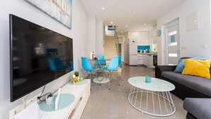A modern living room with a flat-screen TV, blue chairs, a round coffee table, and a sofa with yellow cushions. - Stunning home in Zaton (Zaton)