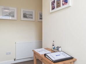 A room with a wooden table, framed pictures on the wall, and a small model ship.