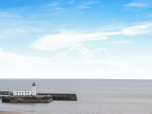 Un phare situé sur la côte, avec un ciel dégagé et une mer calme.