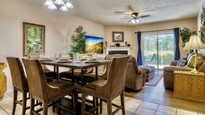 A dining area with a table set for four, surrounded by chairs.
