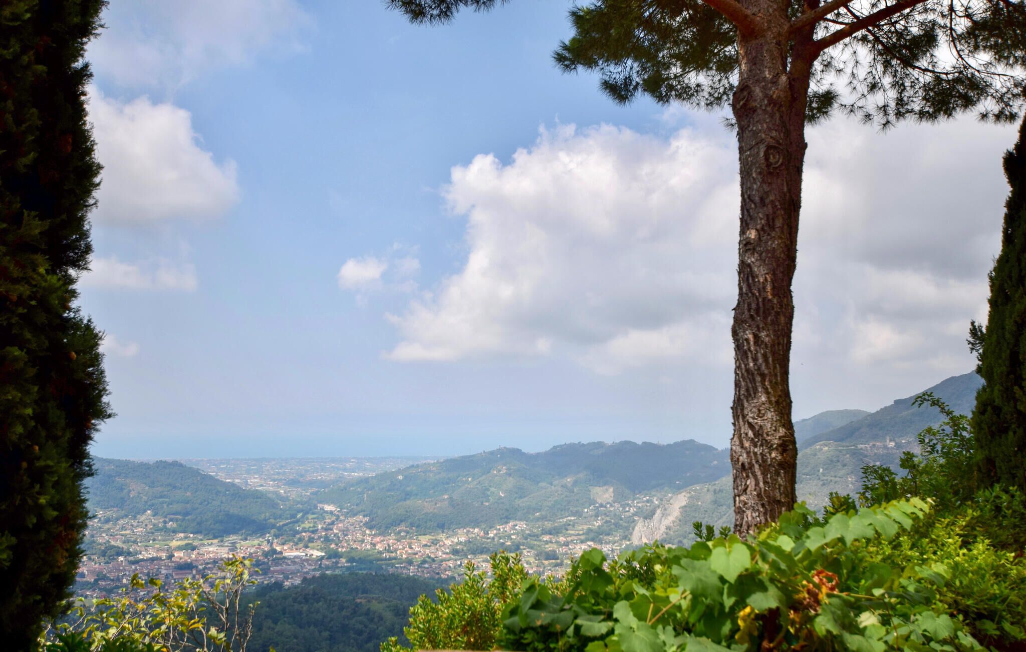 A panoramic view of a town nestled in a valley with mountains in the background.