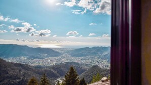 A panoramic view of a valley with a distant body of water, surrounded by hills and trees. - Cozy home in Metato with kitchen (Metato)