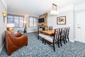 A dining area with a wooden table and chairs, a stone fireplace, and a television mounted on the wall. - South Lake Tahoe at Stateline. Marriott Timber Lodge 2 bedroom, 2 bath Villa! (South Lake Tahoe)