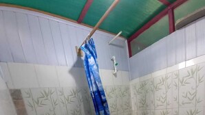 Un baño pequeño con inodoro, cortina de ducha y paredes con azulejos.