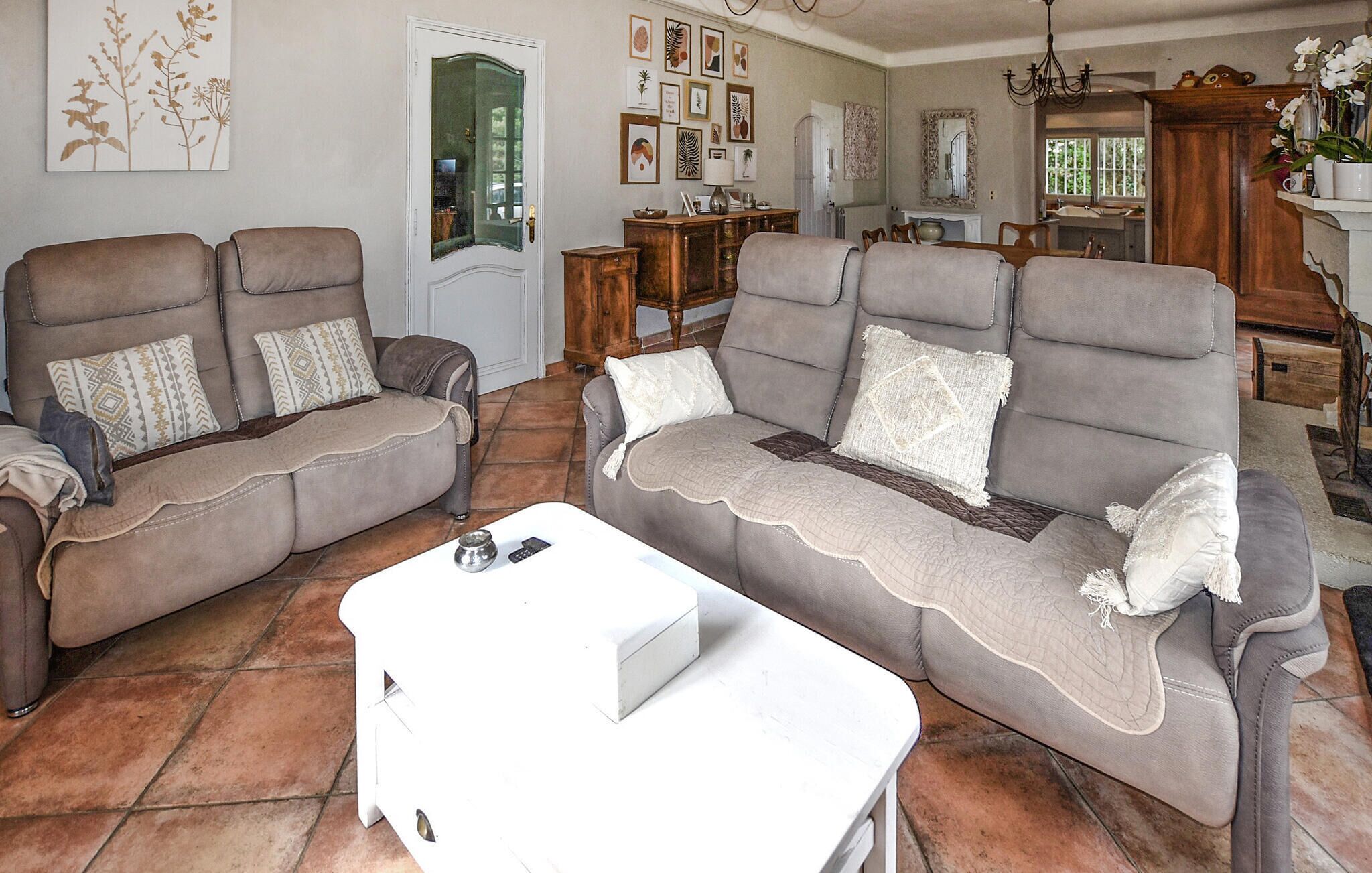 A living room with two sofas, a coffee table, and a dining area in the background.