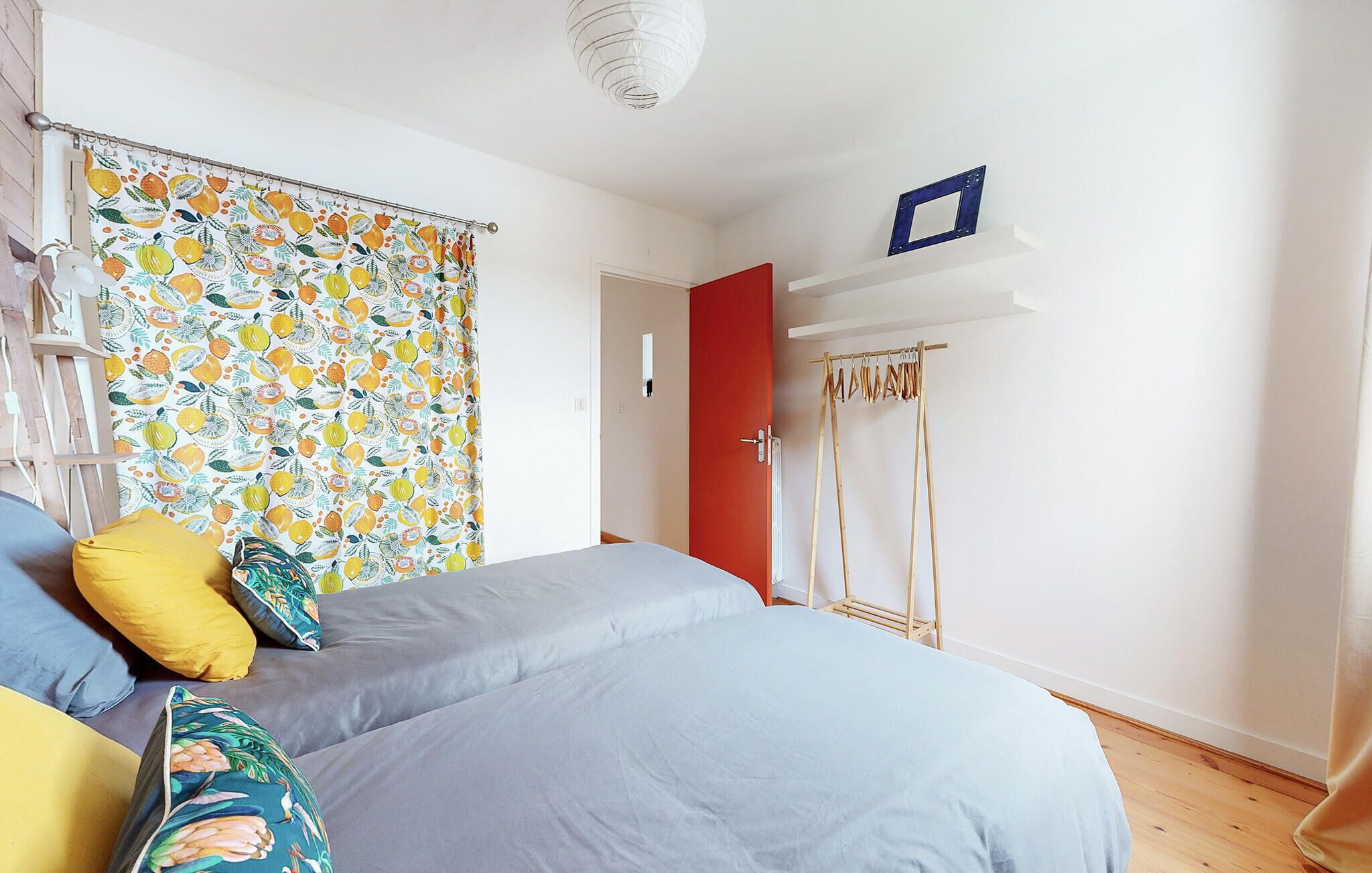 Ein Schlafzimmer mit Bett, Schrank, Tür und einer Kleiderstange.